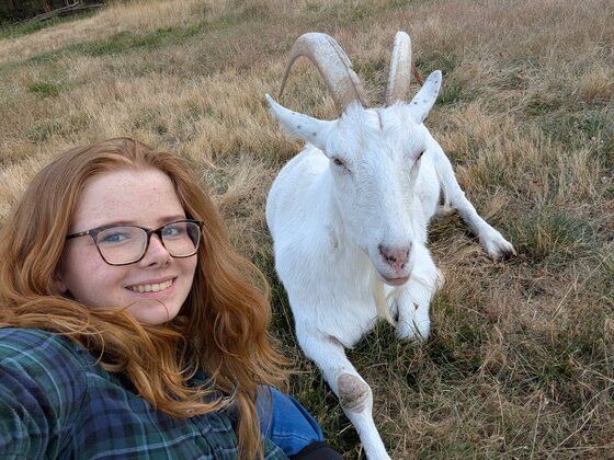 Isabella taking a selfie with a white goat